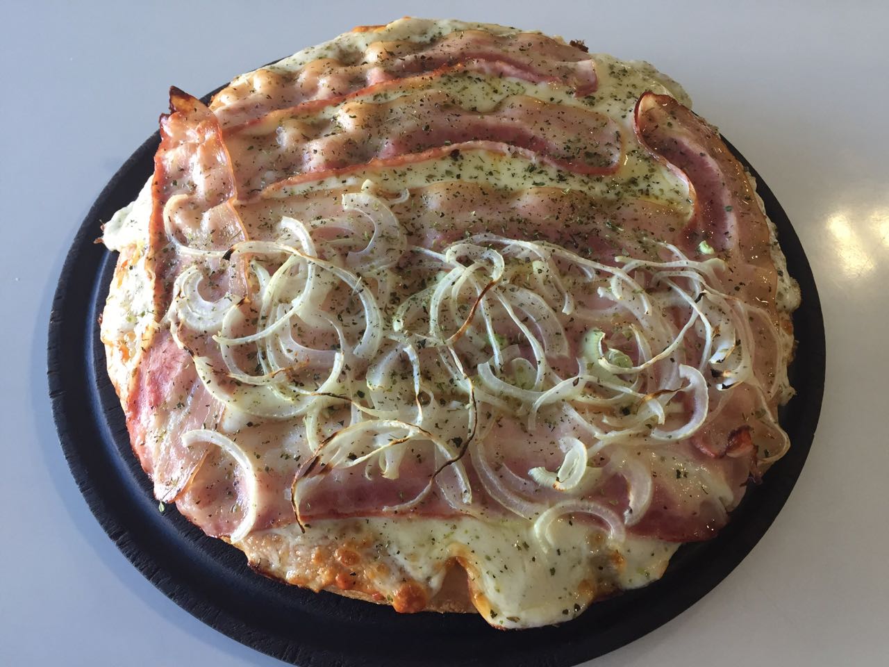 Pizza Horacito, uno de los hits del boliche, con panceta dorada